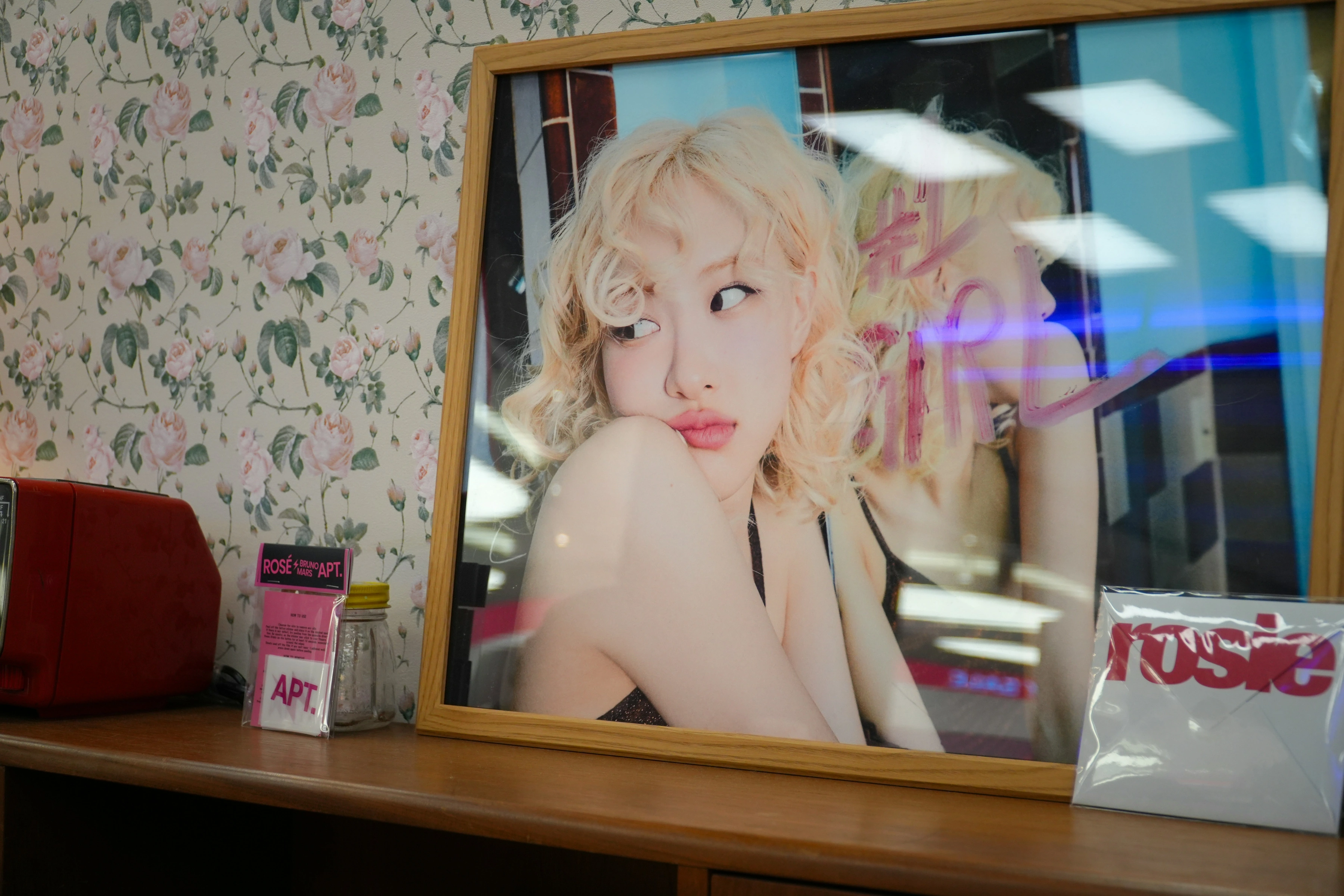 로제의 사진 액자와 APT. 및 rosie 관련 상품이 함께 진열된 모습